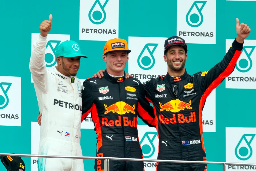 Lewis Hamilton, Max Verstappen and Daniel Ricciardo celebrating on the podium in front of Petronas branding after the 2017 Malaysian Grand Prix